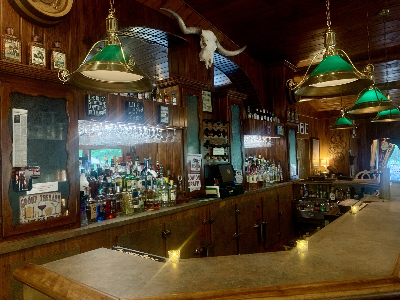 The Log Cabin Grill and Bar interior with green lamps and horns